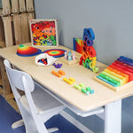 A table full of Grimm's Wooden educational and number toys, ready for learning