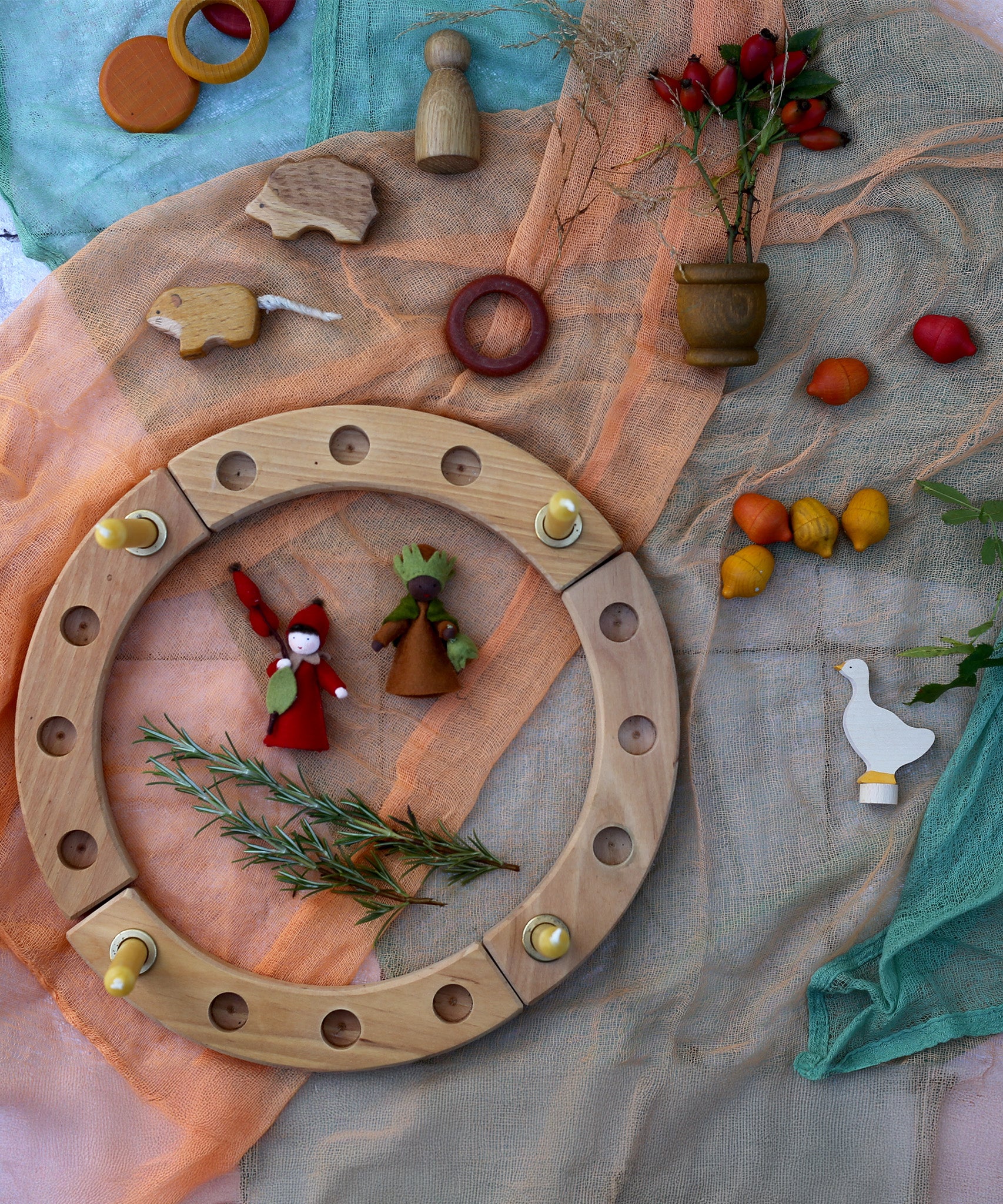 A beautiful Autumnal display using a Grimm's Celebration Ring, loose parts laid on top of decorative scarfs