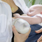 A person breast feeding and using the Generation 3 160ml Breast Pump