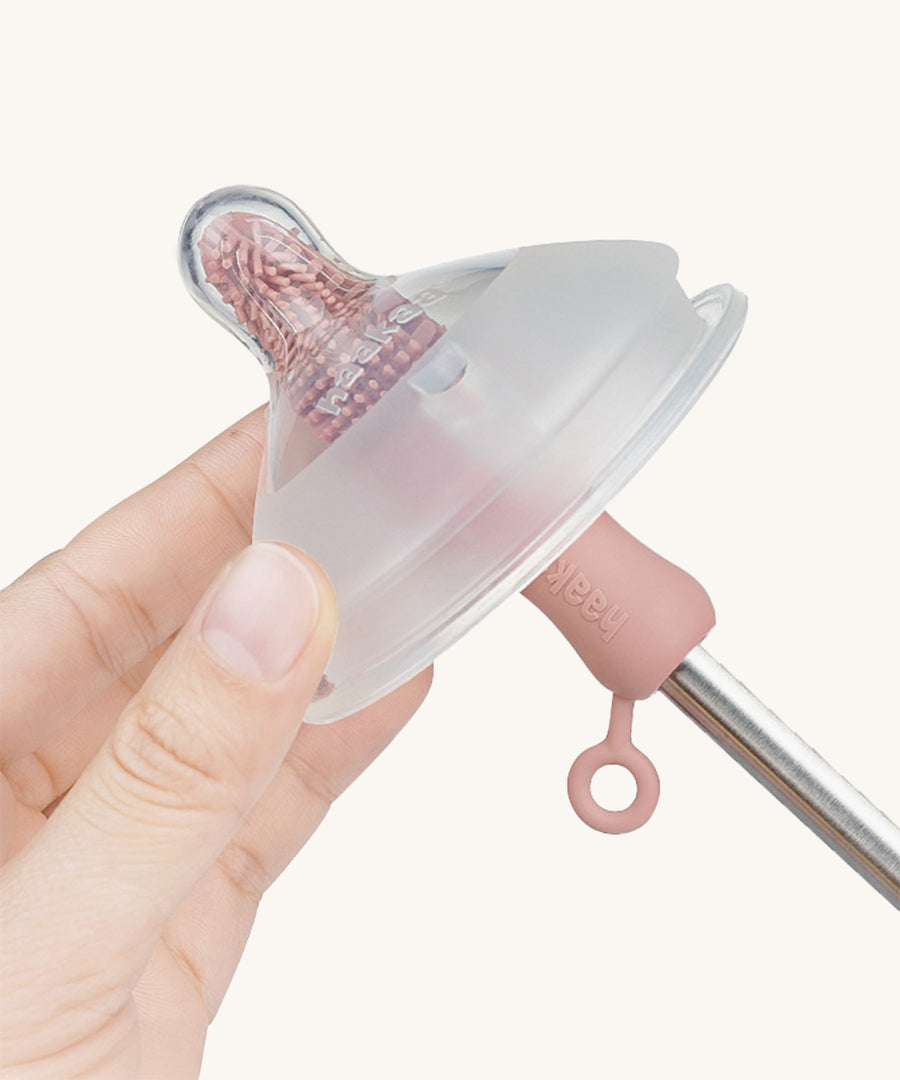 The Haakaa Silicone Cleaning Brush being used to clean a Haakaa bottle nipple