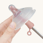 The Haakaa Silicone Cleaning Brush being used to clean a Haakaa bottle nipple