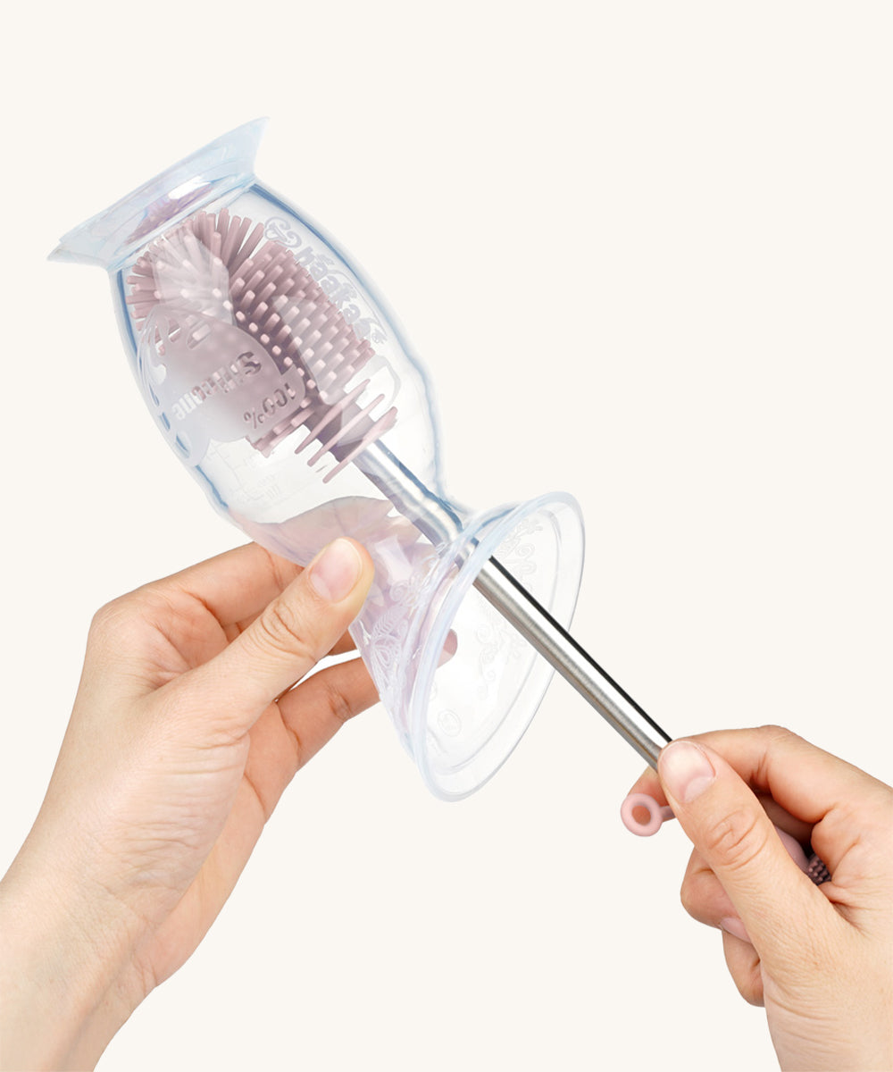 The Haakaa Silicone Cleaning Brush being used to clean a Haakaa Breast Pump