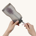 The Haakaa Silicone Cleaning Brush being used to clean a Haakaa food pouch