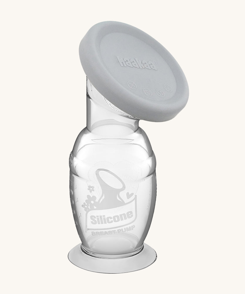 Haakaa Generation 2 Silicone Breast Pump with Suction Base and grey cap on a cream background