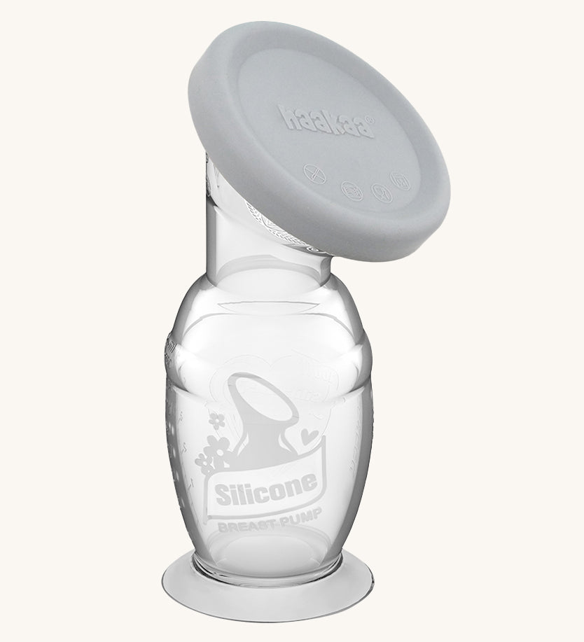 Haakaa Generation 2 Silicone Breast Pump with Suction Base and grey cap on a cream background