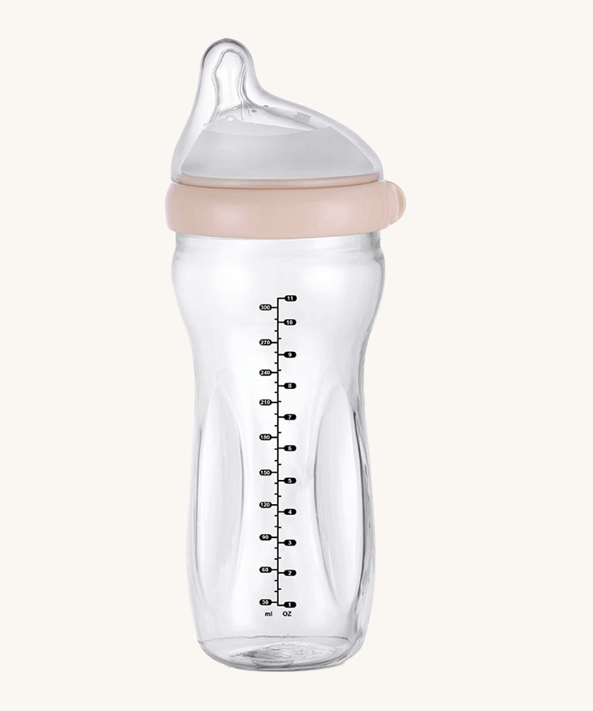 The Haakaa Generation 3 Glass Baby Bottle 300ml in peach, on a cream background