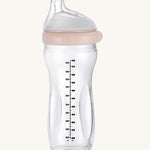 The Haakaa Generation 3 Glass Baby Bottle 300ml in peach, on a cream background