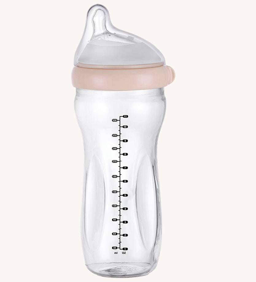 The Haakaa Generation 3 Glass Baby Bottle 300ml in peach, on a cream background