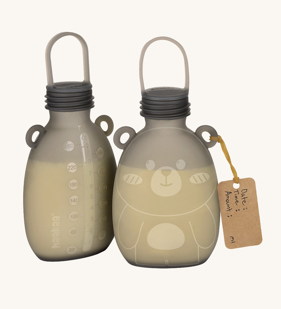 The Haakaa Happii Bear Milk Storage Bag, with one showing the easy to read measurements on the back to keep track of consumption, and the other side is of the Happii Bear print