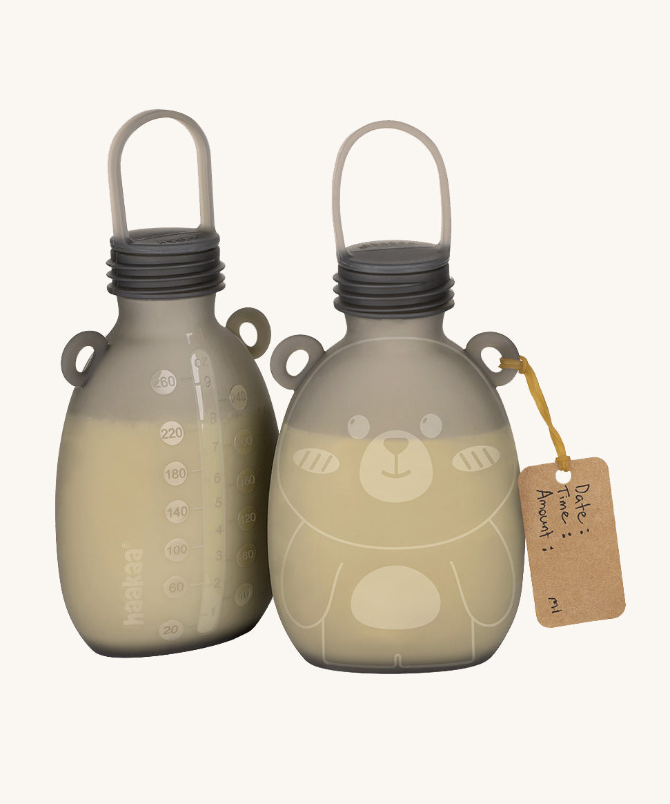 The Haakaa Happii Bear Milk Storage Bag, with one showing the easy to read measurements on the back to keep track of consumption, and the other side is of the Happii Bear print