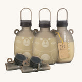 Three Haakaa Happii Bear Milk Storage Bags with 2 rolled up bags in front to show how durable, flexible and compact the storage bags are