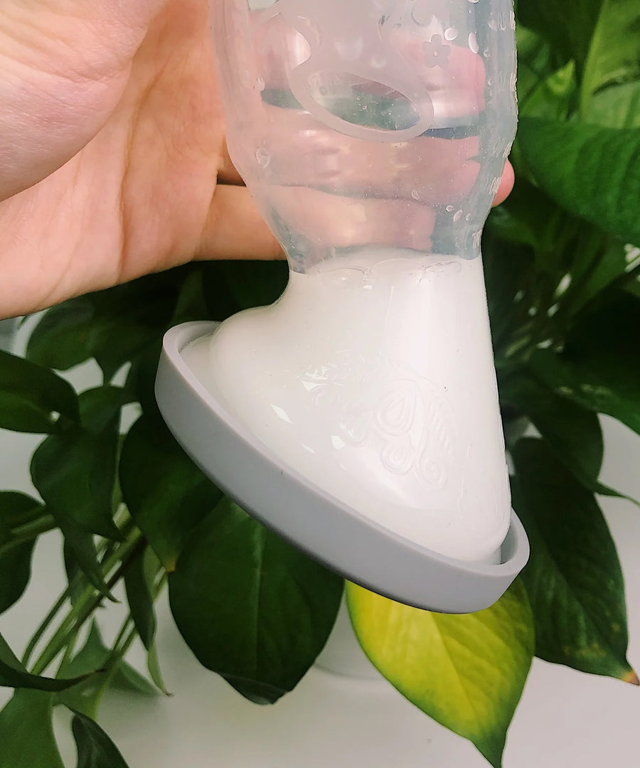 A person turning the Generation 1 100ml Silicone Breast Pump & Silicone Cap upside down to show it is leakproof