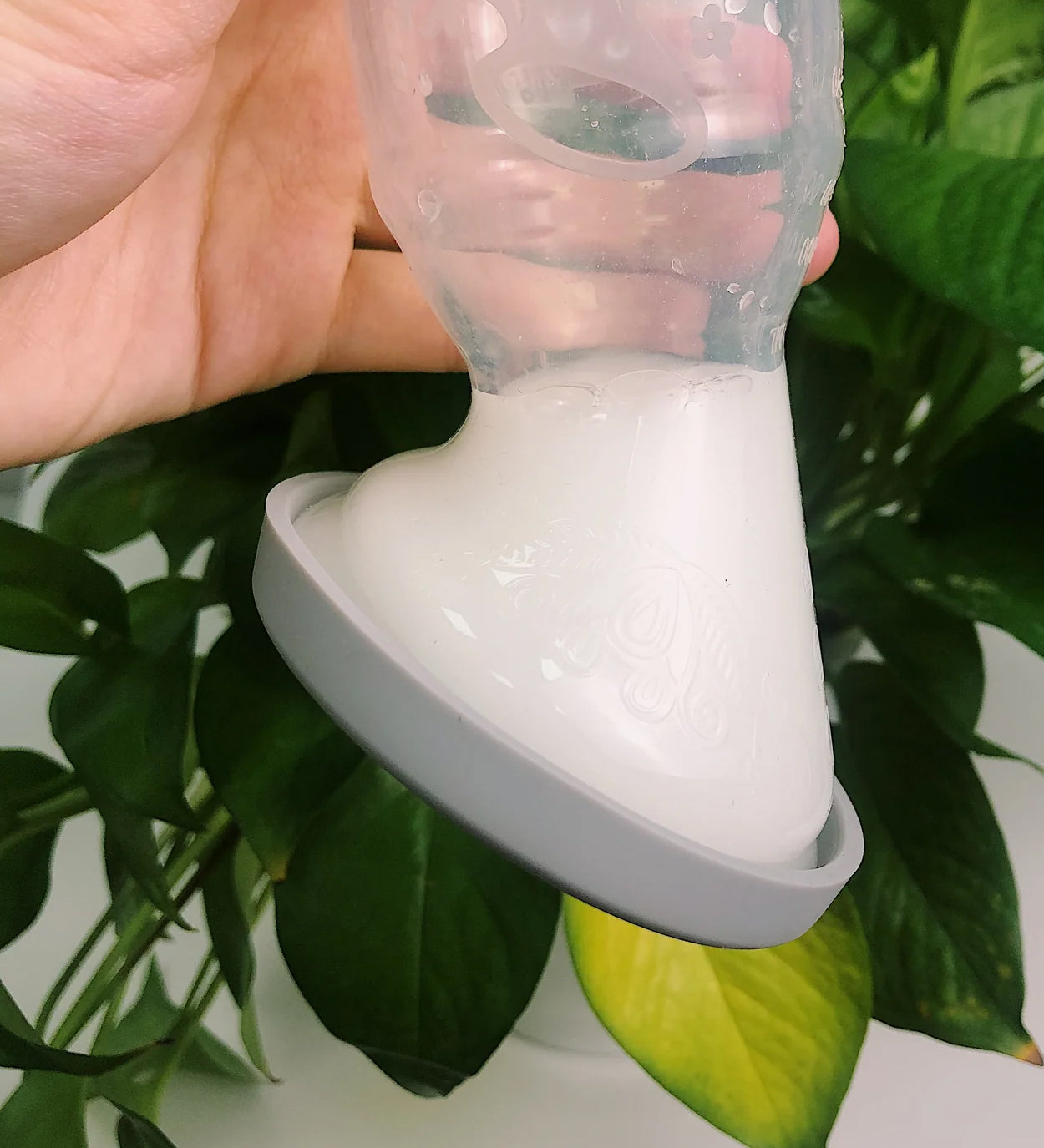 A person turning the Generation 1 100ml Silicone Breast Pump & Silicone Cap upside down to show it is leakproof