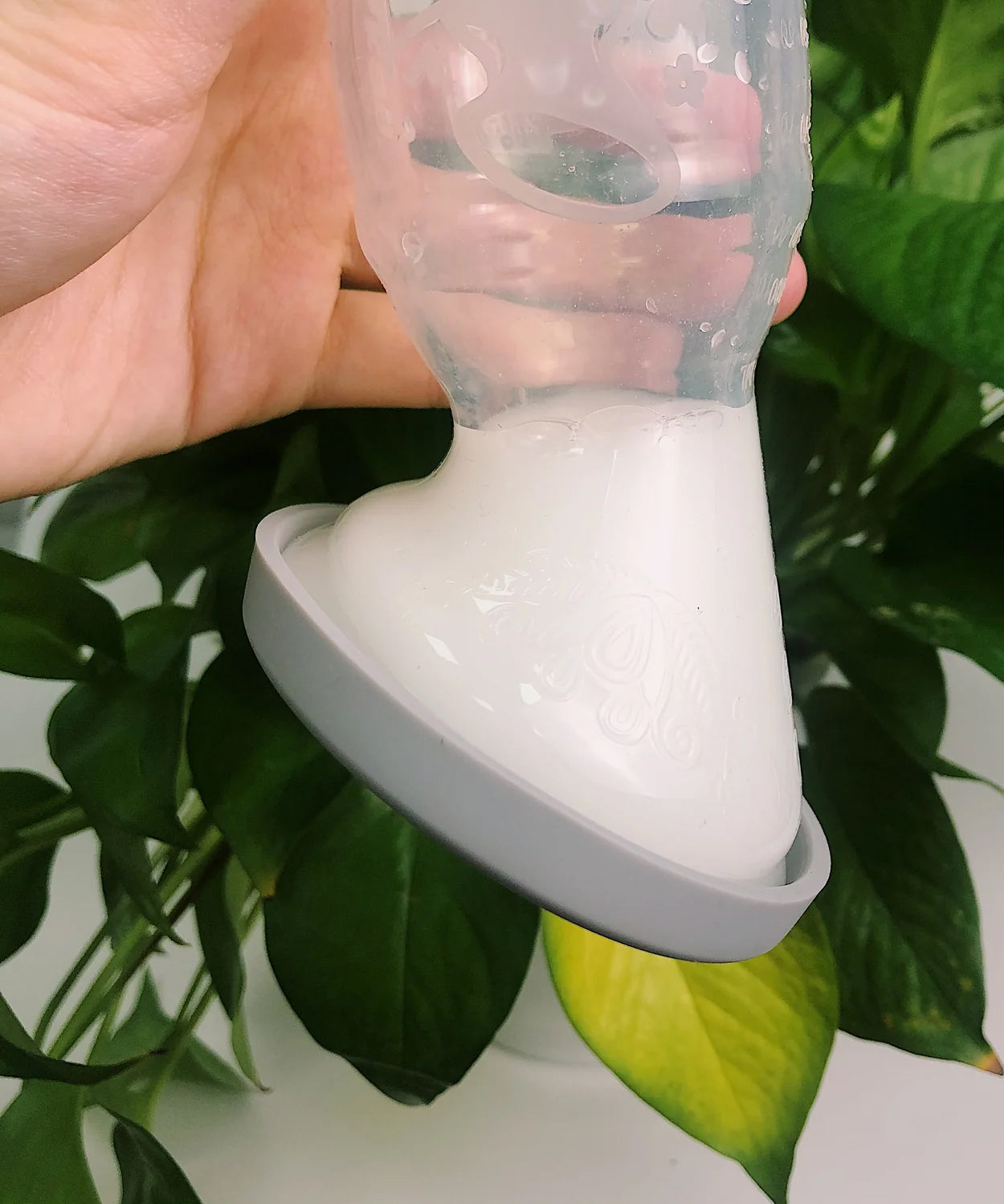 A person turning the Generation 1 100ml Silicone Breast Pump & Silicone Cap upside down to show it is leakproof