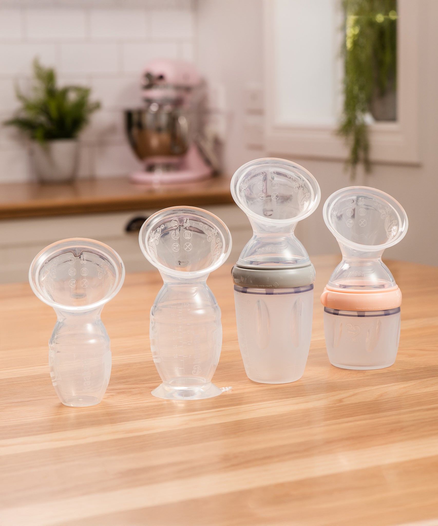 A collection of Haaka Breast Pumps from Generation 1, 2 and 3, each with various attachments