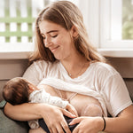 A parent breastfeeding their child, and using the Generation 1 100ml Silicone Breast Pump