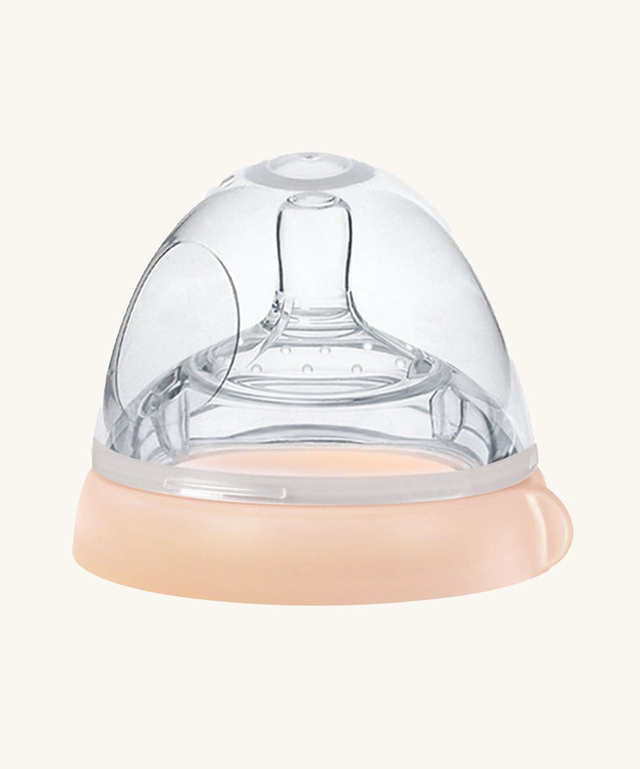 The Haakaa Bottle Nipple and Cap Generation 3 in peach, on a cream background