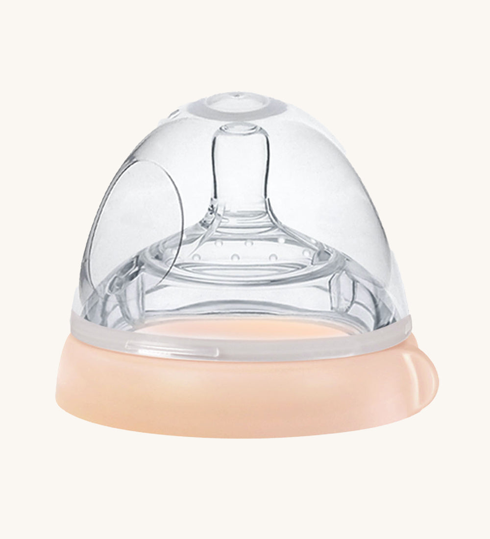 The Haakaa Bottle Nipple and Cap Generation 3 in peach, on a cream background