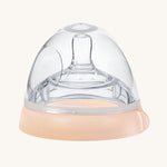 The Haakaa Bottle Nipple and Cap Generation 3 in peach, on a cream background