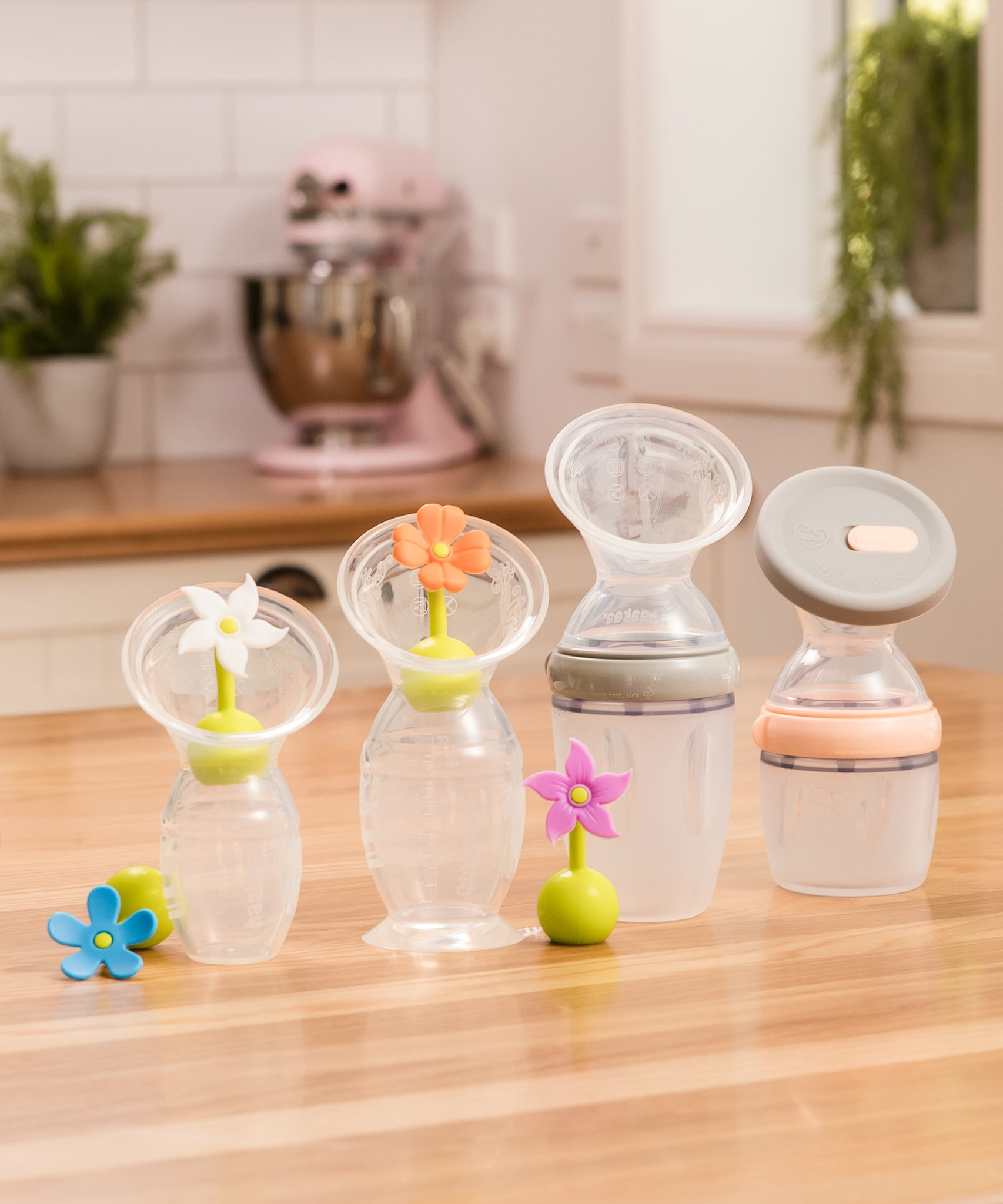 A collection of Haakaa Breast Pumps from Generation 1, 2 and 3, each with various attachments and accessories