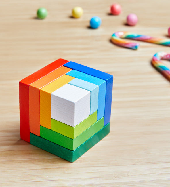 A wooden 3D Haba rainbow cube arranging puzzle on a table