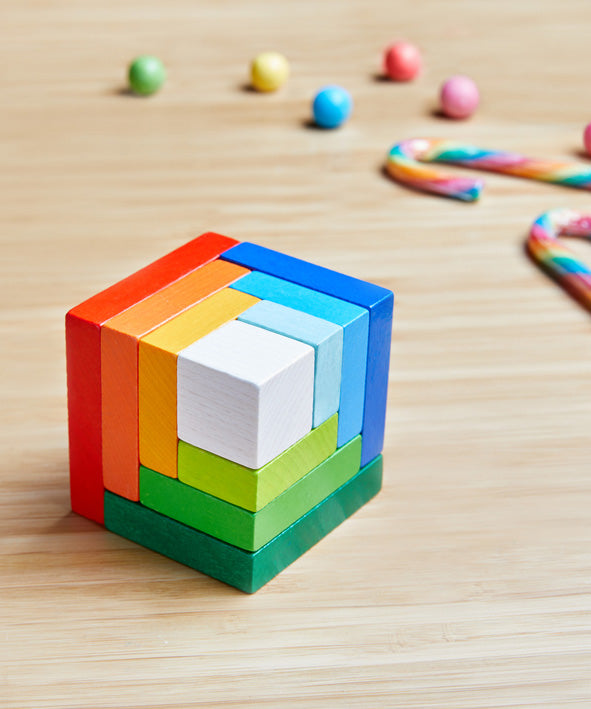 A wooden 3D Haba rainbow cube arranging puzzle on a table