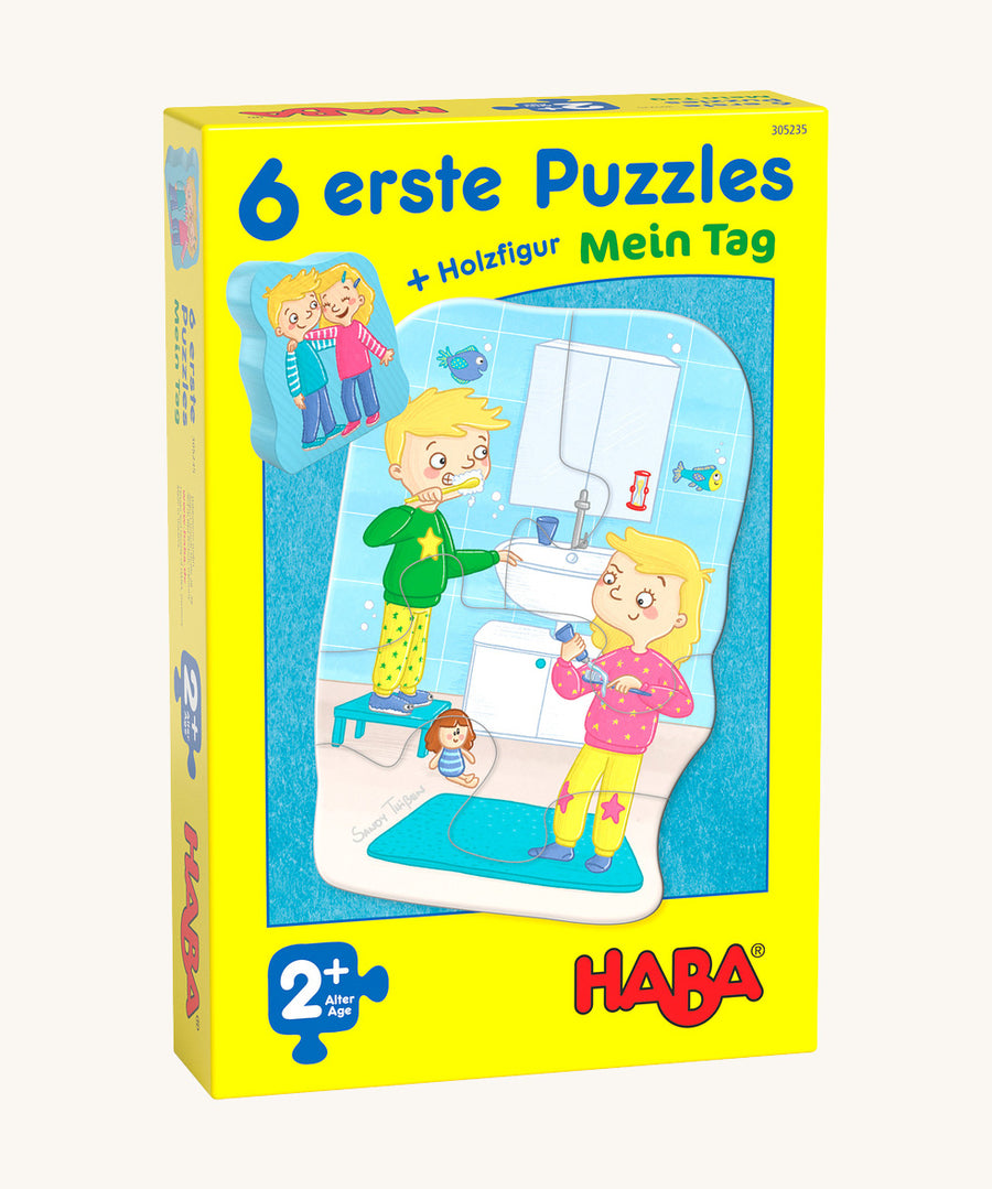 A yellow cardboard box with a picture of a boy and girl brushing their teeth for the Haba my day jigsaw set on a cream background