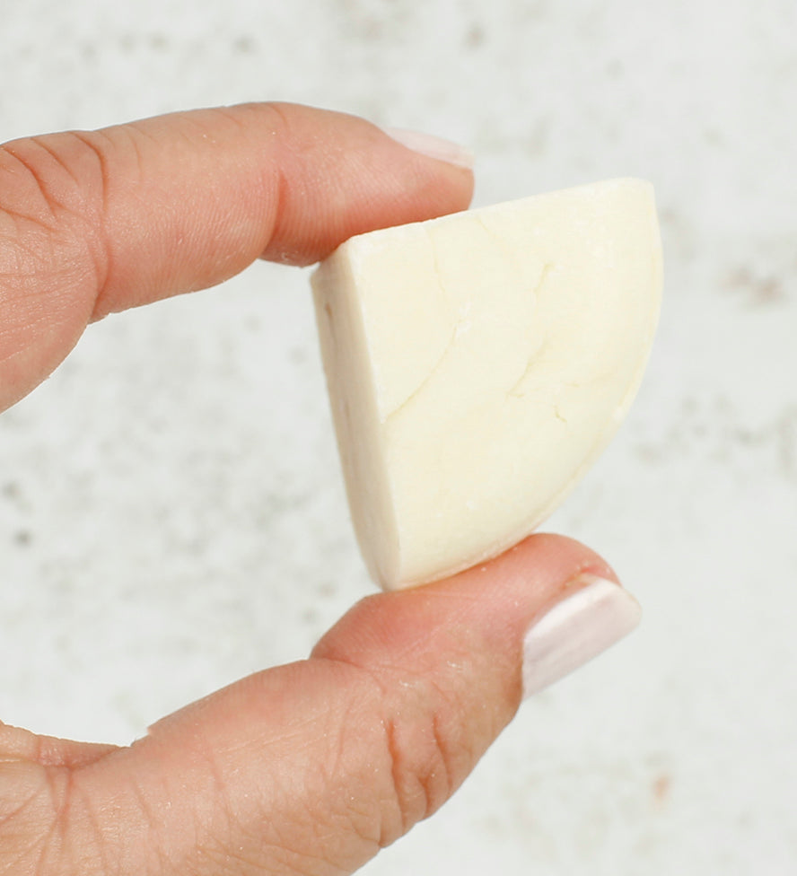 A person holding a piece of the Shower Blocks 1/4 Bar Sample - Sweet Orange & Bergamot