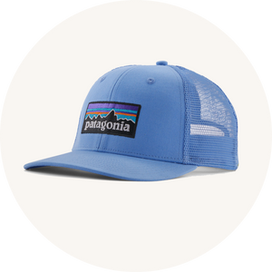 Patagonia blue trucker hat on cream background to represent Patagonia adult's hats at Babipur.