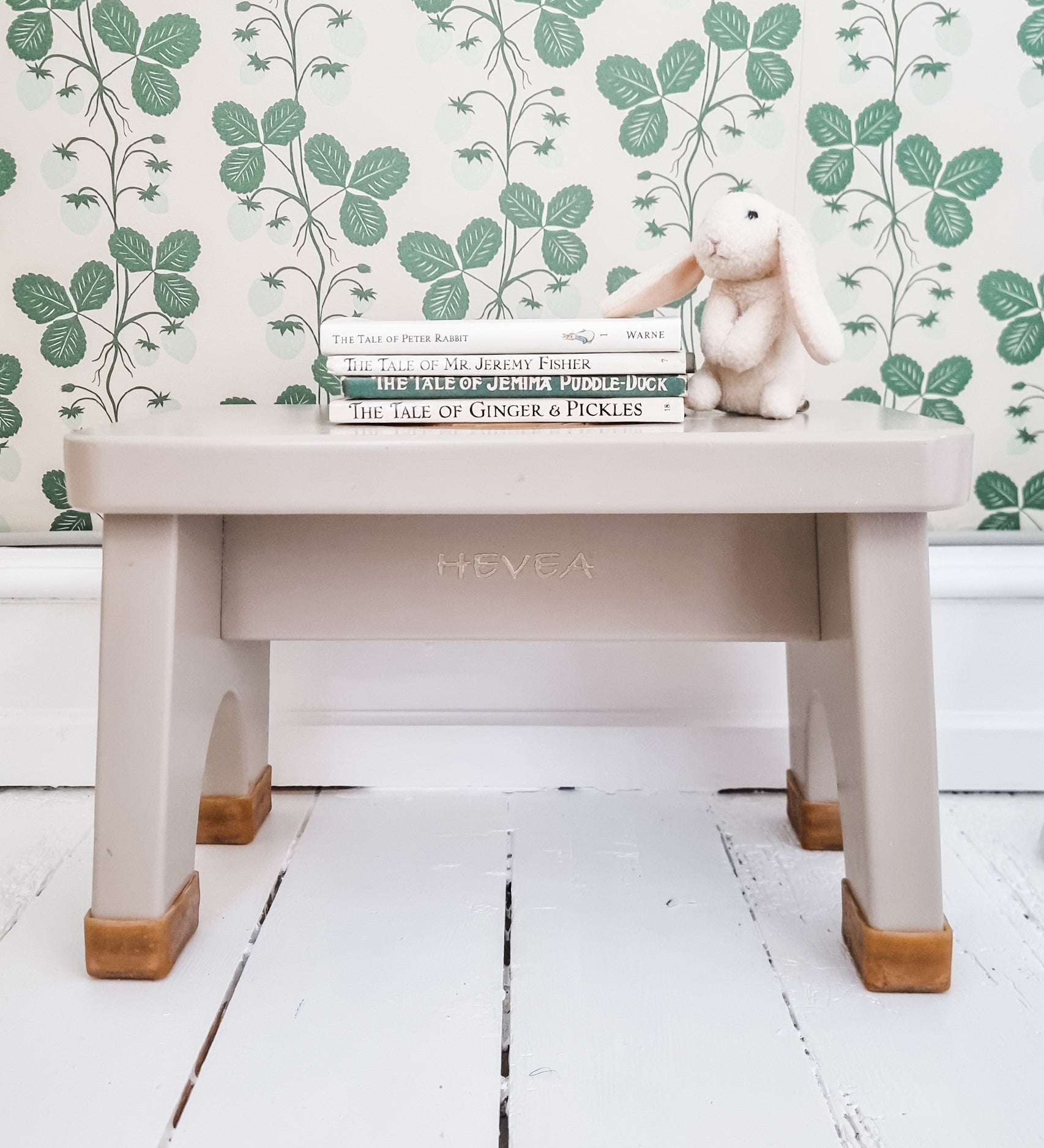 Hevea Rubberwood Step Stool in pink with a stack of children's books on the top and a toy rabbit.