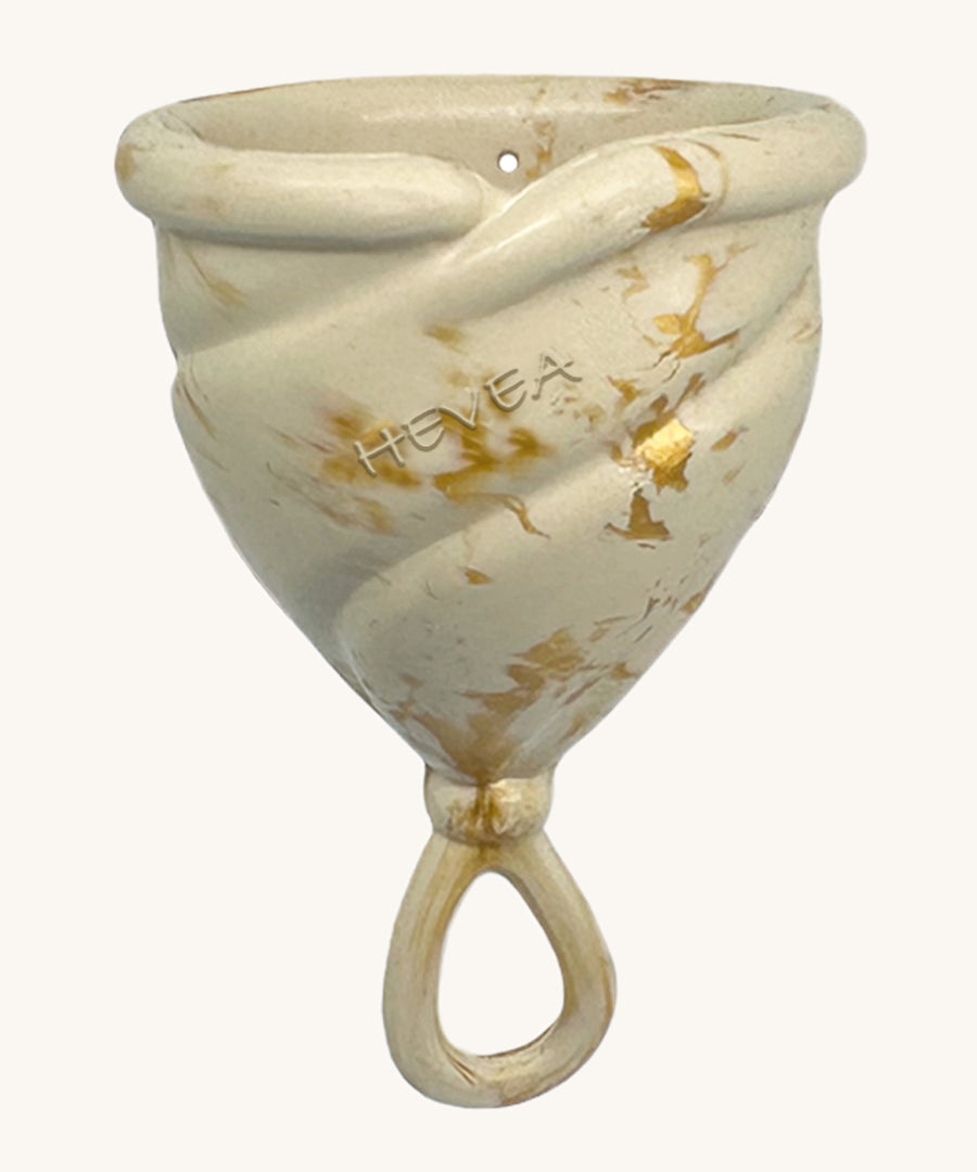 Hevea LOOP Menstrual Cup Size 2 - Golden Sand, a cream natural rubber menstrual cup with gold flecks and a loop stem. 