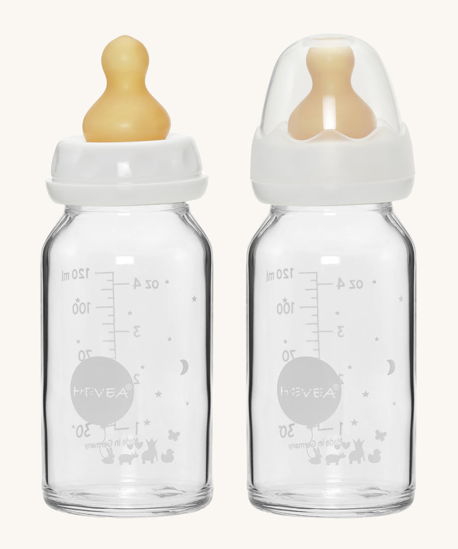 A pack of two Hevea glass baby bottles 120ml with natural rubber teats, one with the dust cap, one without. 