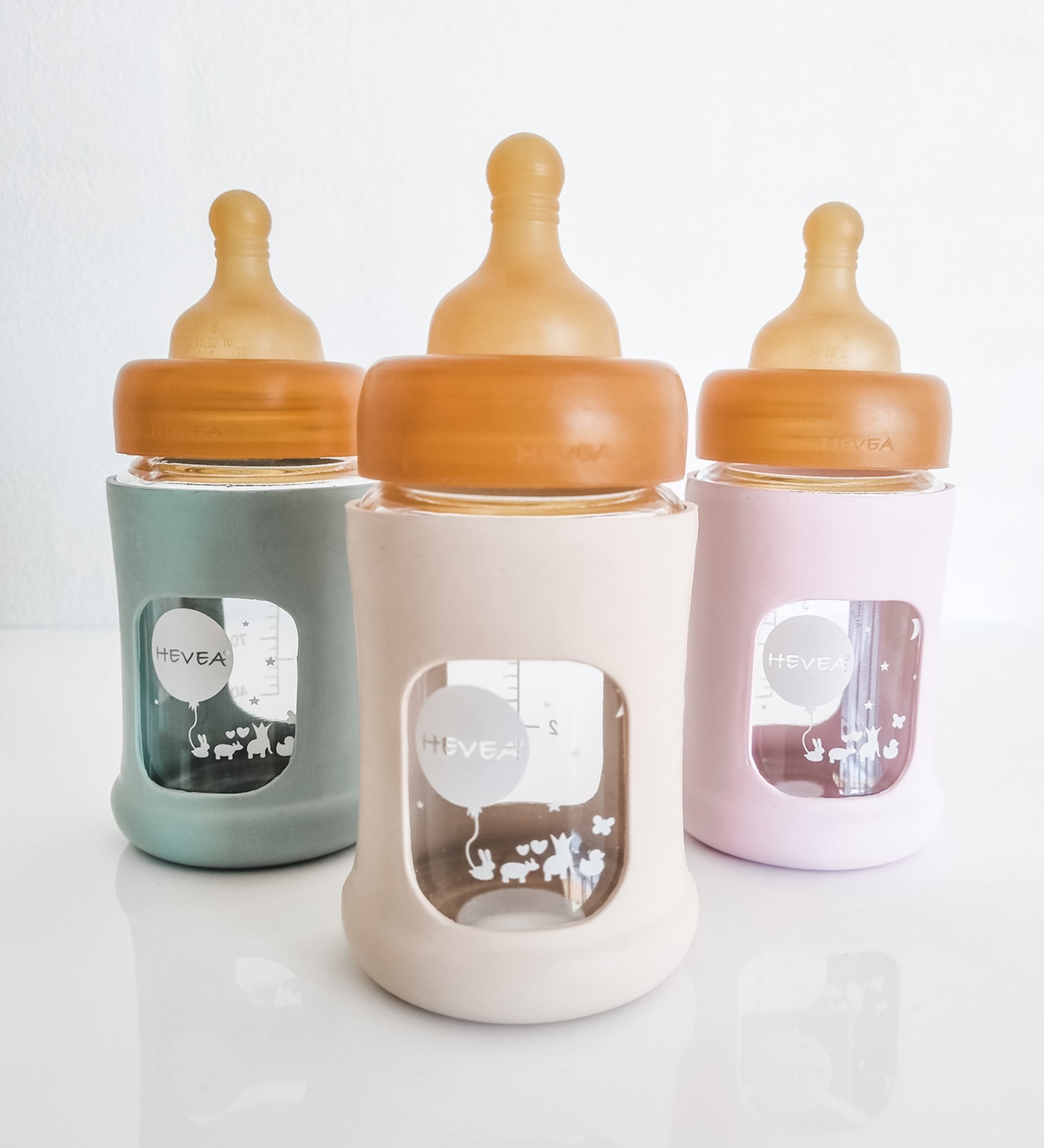 Hevea Glass Baby Bottle Wide Neck With Rubber Sleeve - 150ml in Seafoam Blue, Sand and Powder Pink