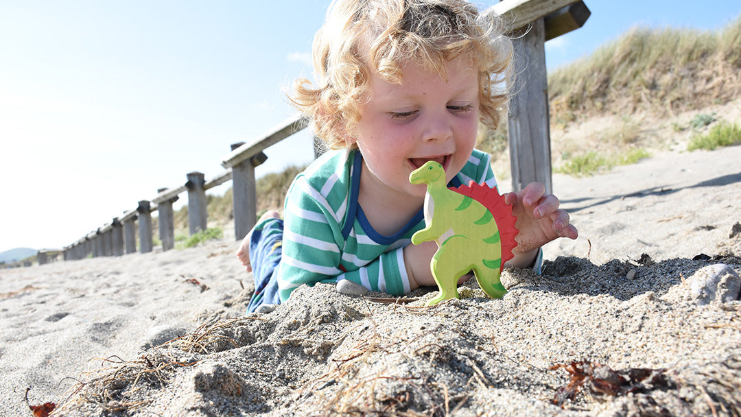 Little boy playing with Holztiger wooden dinosaur