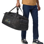 A person carrying the Patagonia Black Hole Duffel 70L Ink Black, with the carry handles