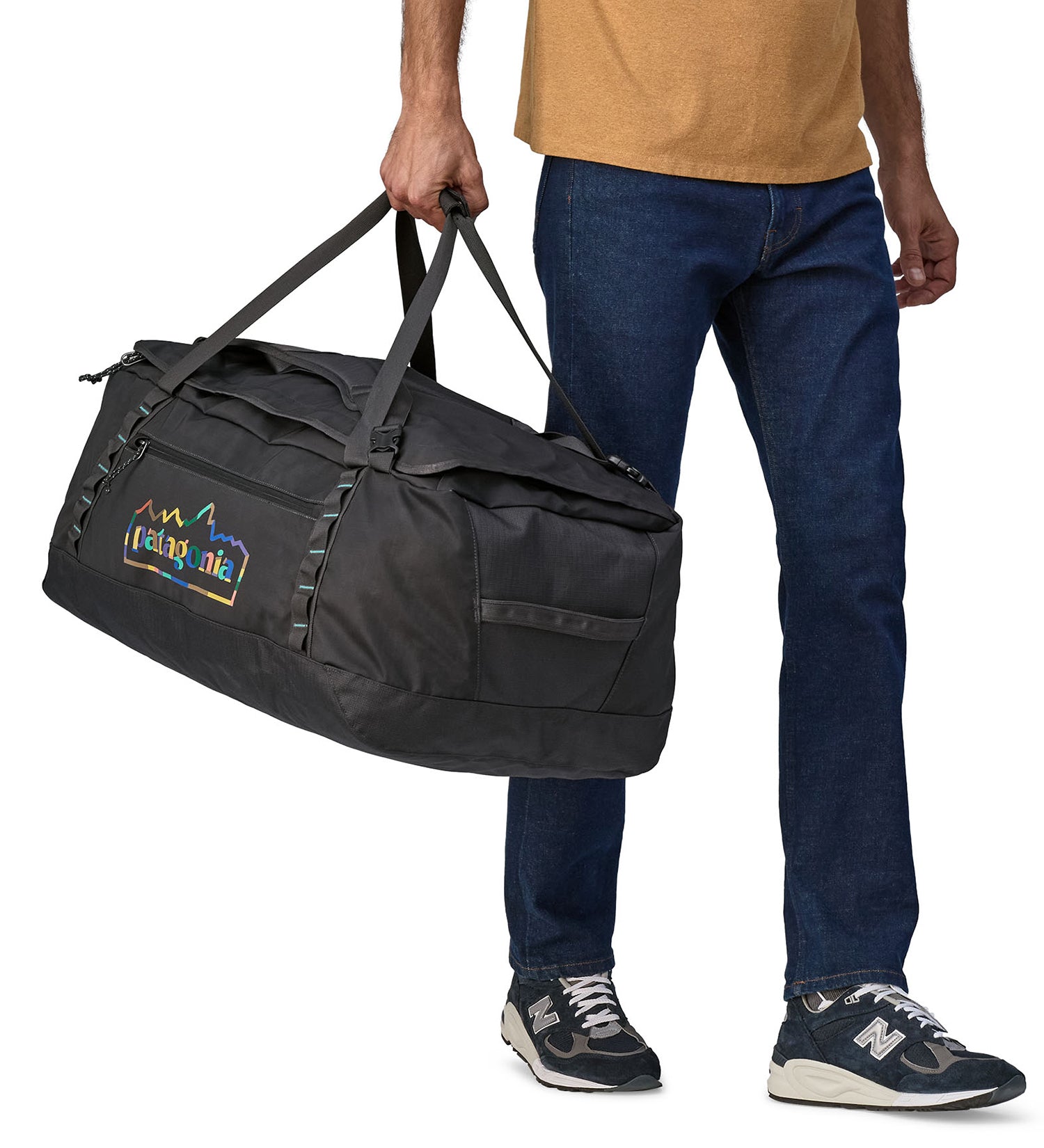 A person carrying the Patagonia Black Hole Duffel 70L Ink Black, with the carry handles