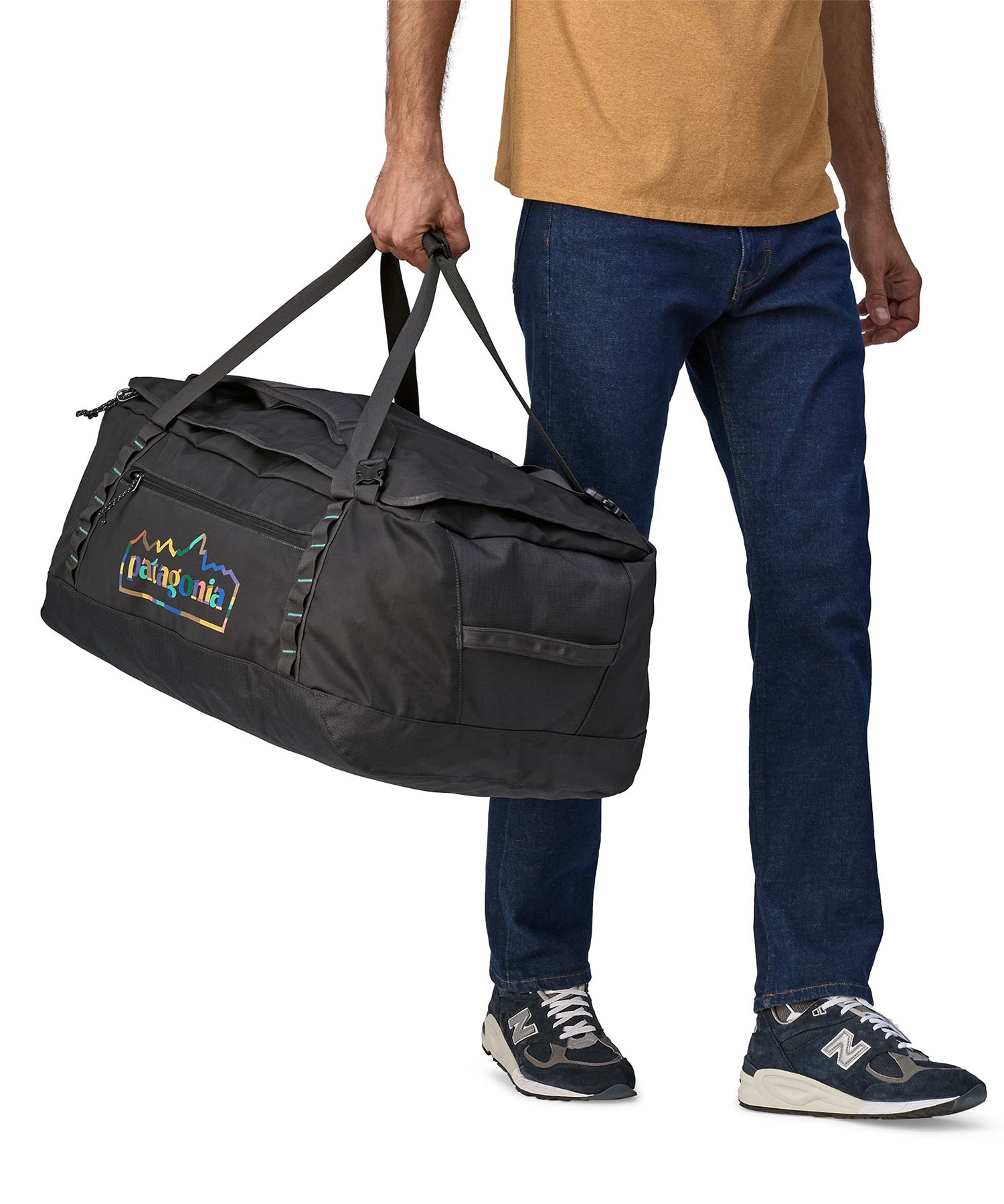 A person carrying the Patagonia Black Hole Duffel 70L Ink Black, with the carry handles