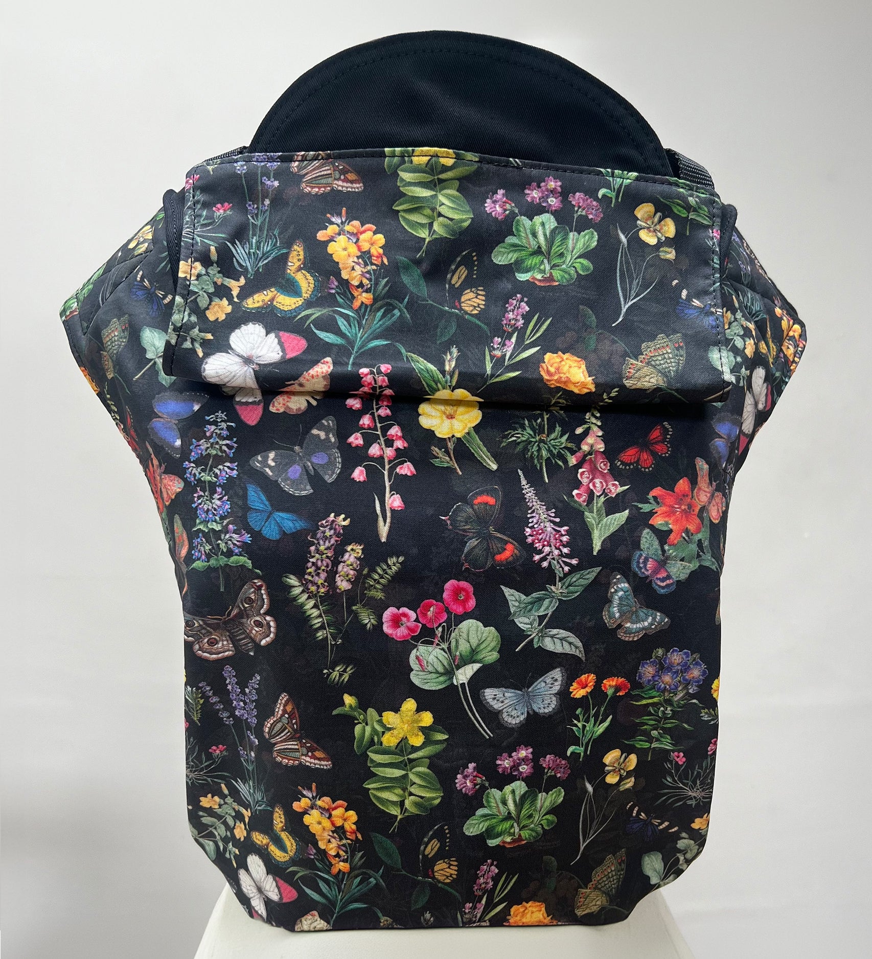 Integra Size 3 baby carrier, Flower Garden. Flower Garden is a beautifully illustrated floral design in soft organic cotton featuring colourful garden flowers and butterflies on a black background.