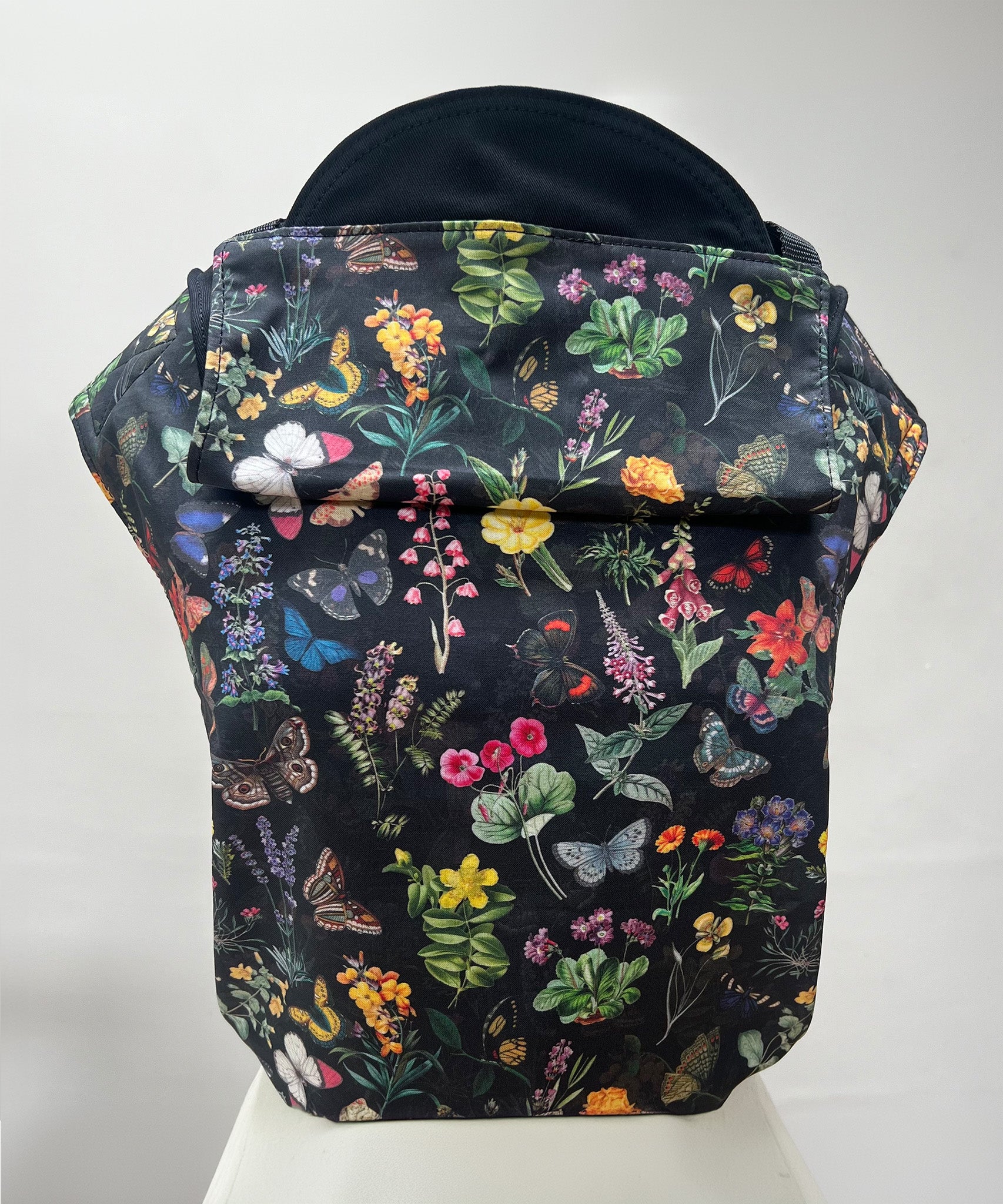 Integra Size 3 baby carrier, Flower Garden. Flower Garden is a beautifully illustrated floral design in soft organic cotton featuring colourful garden flowers and butterflies on a black background.