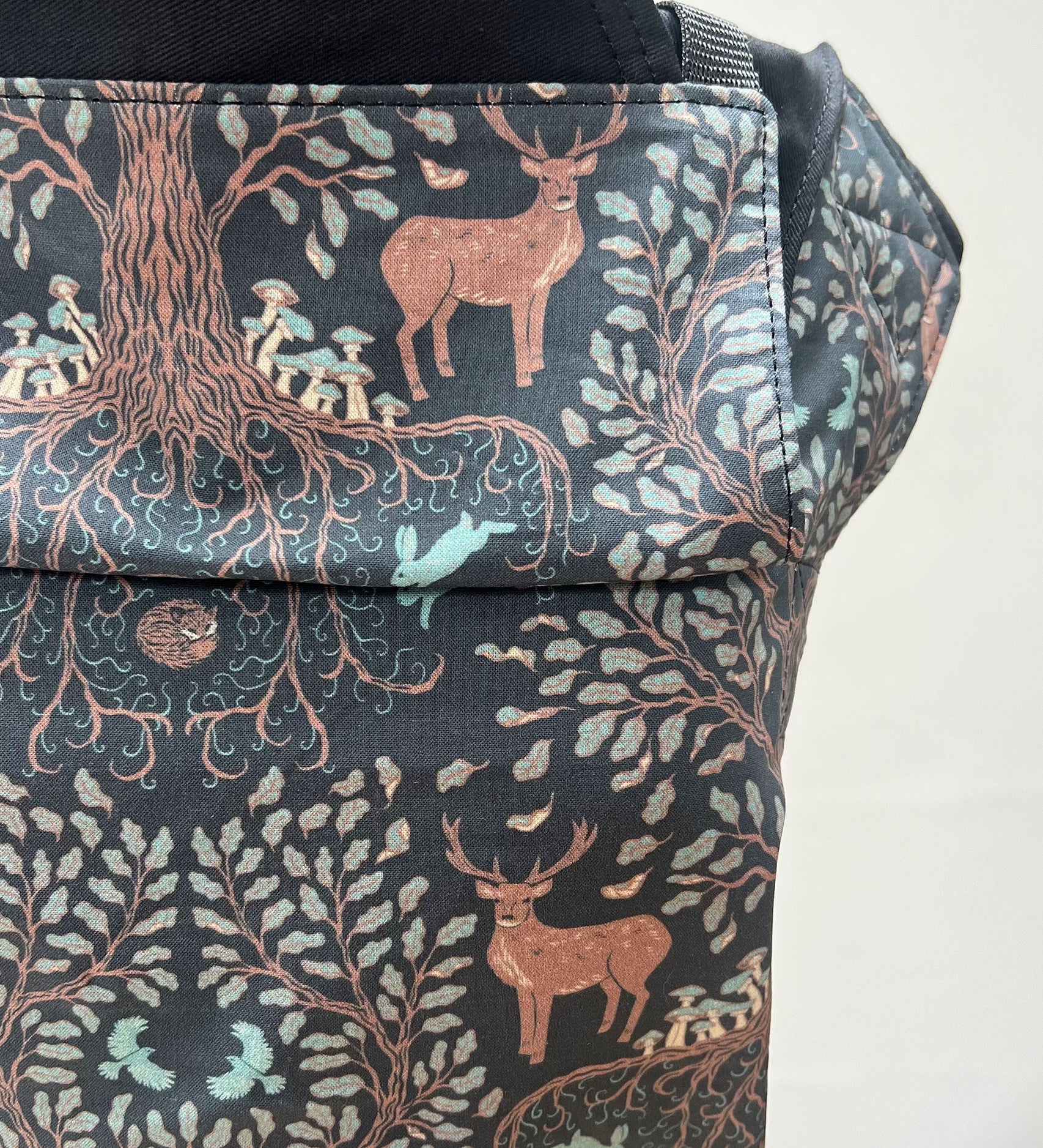 Integra Baby Carrier - Forest Tree. Forest Tree is a beautifully illustrated woodland design in soft organic cotton featuring intricate woodland trees and stags in muted colours on a black background.