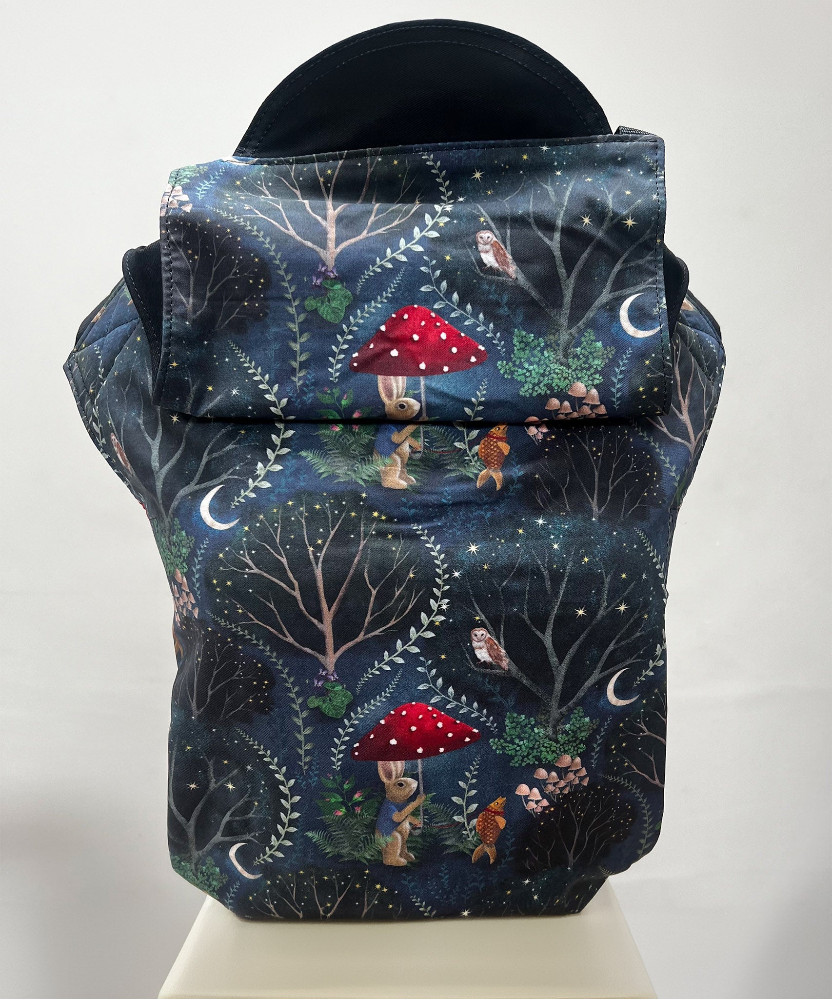 Integra Mr Rabbit Baby Carrier. Mr Rabbit is a whimsical illustrated print in soft organic cotton featuring a rabbit with a red mushroom umbrella taking a pet goldfish for a nighttime walk on an inky black background.