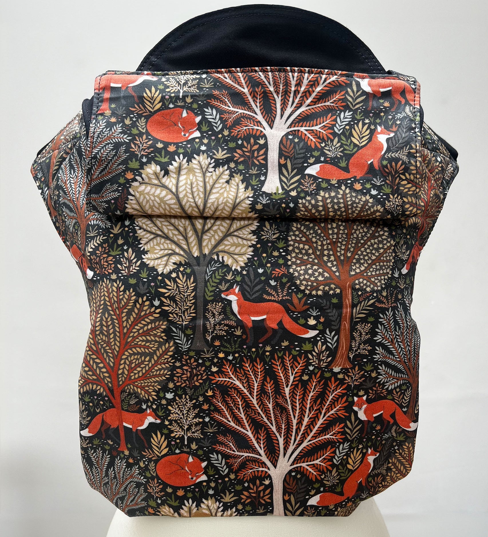 Integra Baby Carrier - Woodland Fox. Woodland Fox is a beautifully illustrated print in soft organic cotton featuring woodland trees in autumnal tones and red foxes on a black background.