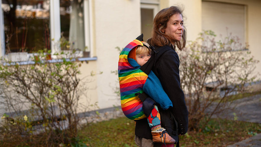 Woman carrying her child in her Integra Babywearing carrier