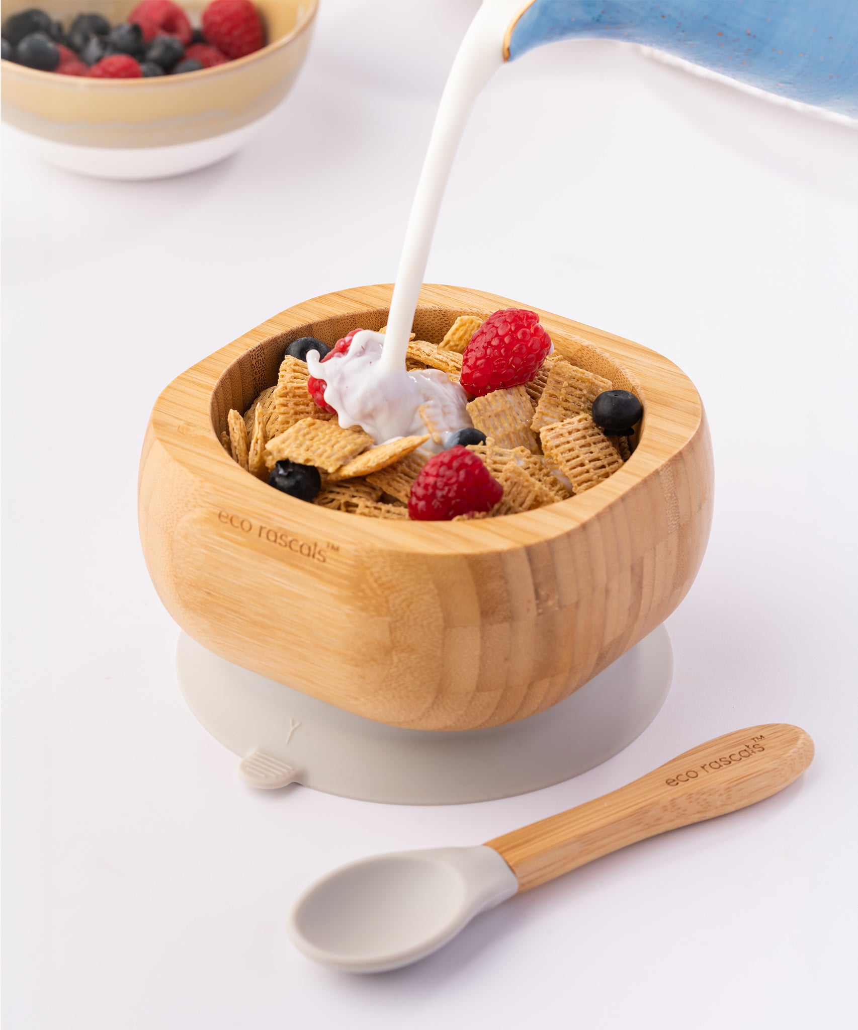 Milk being poured onto breakfast cereal with fresh fruit in the Eco Rascals Bamboo Bowl & Spoon Weaning Set in grey silicone.