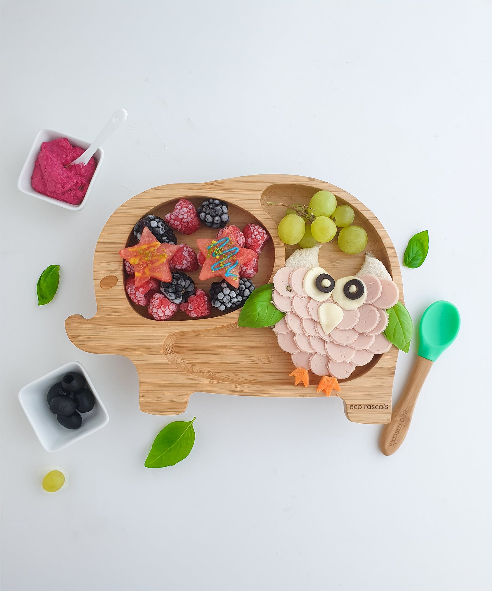 Elephant bamboo baby weaning plate with frozen berries and bamboo baby spoon.