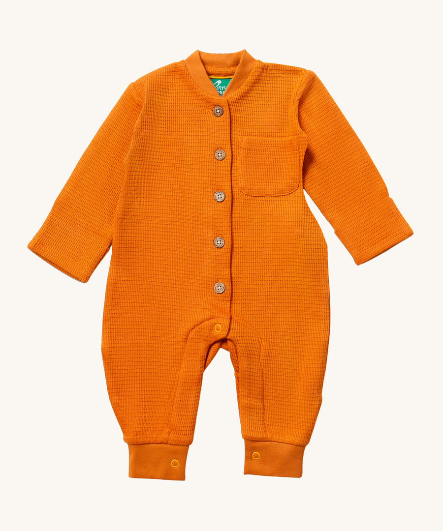 A soft, yellow waffle texture fabric, with buttons down the front and a small pocket on the chest