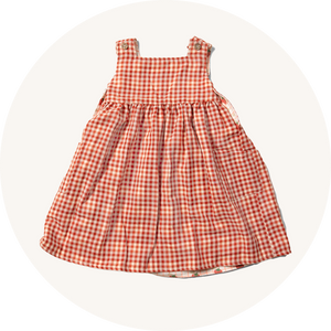 Red checked dress from Little Green Radicals on cream background to represent kids dresses at Babipur.