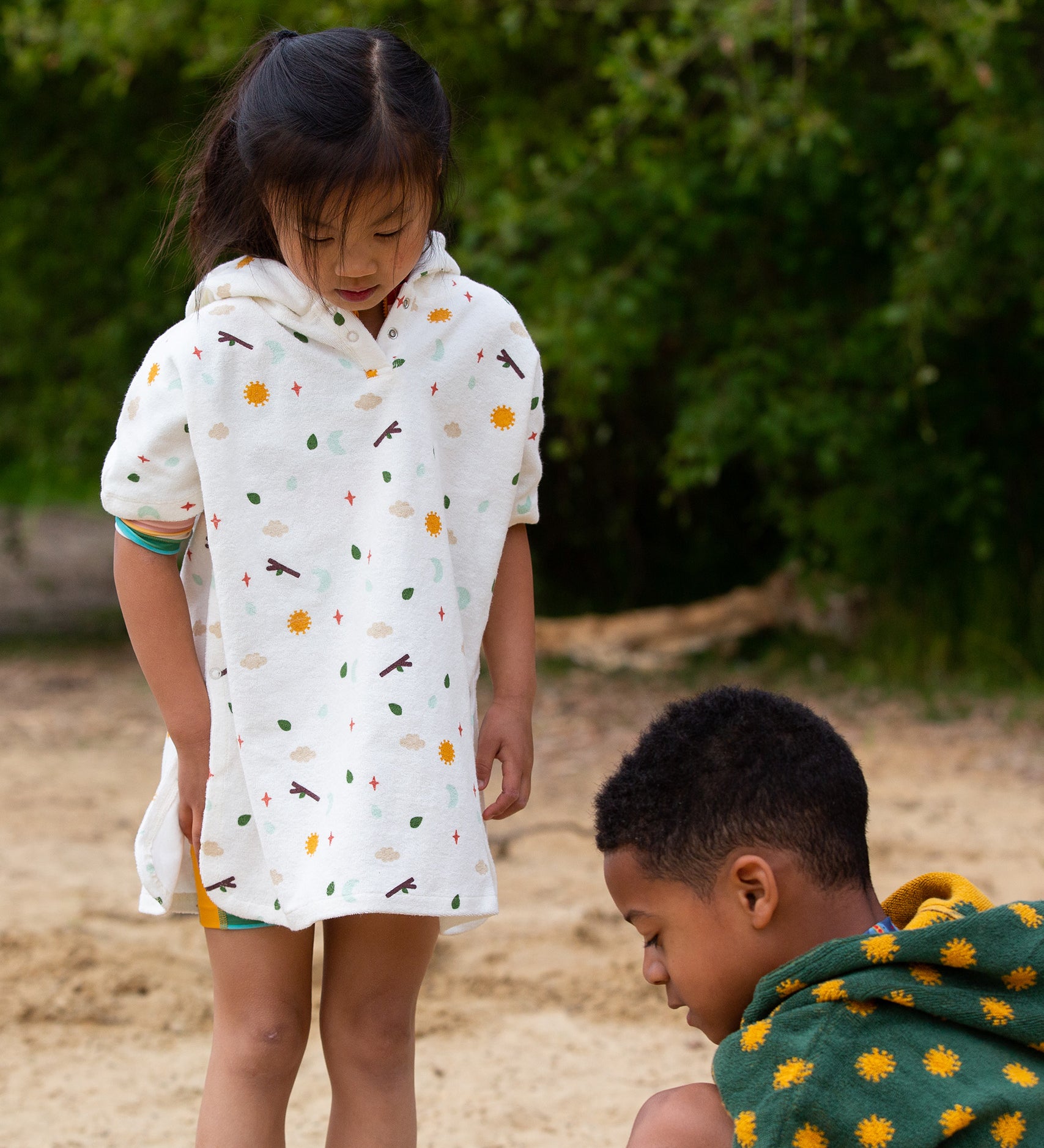 Two children playing at the beach, with the child on the left wearing the LGR Adventure Hooded Beach Towel Poncho