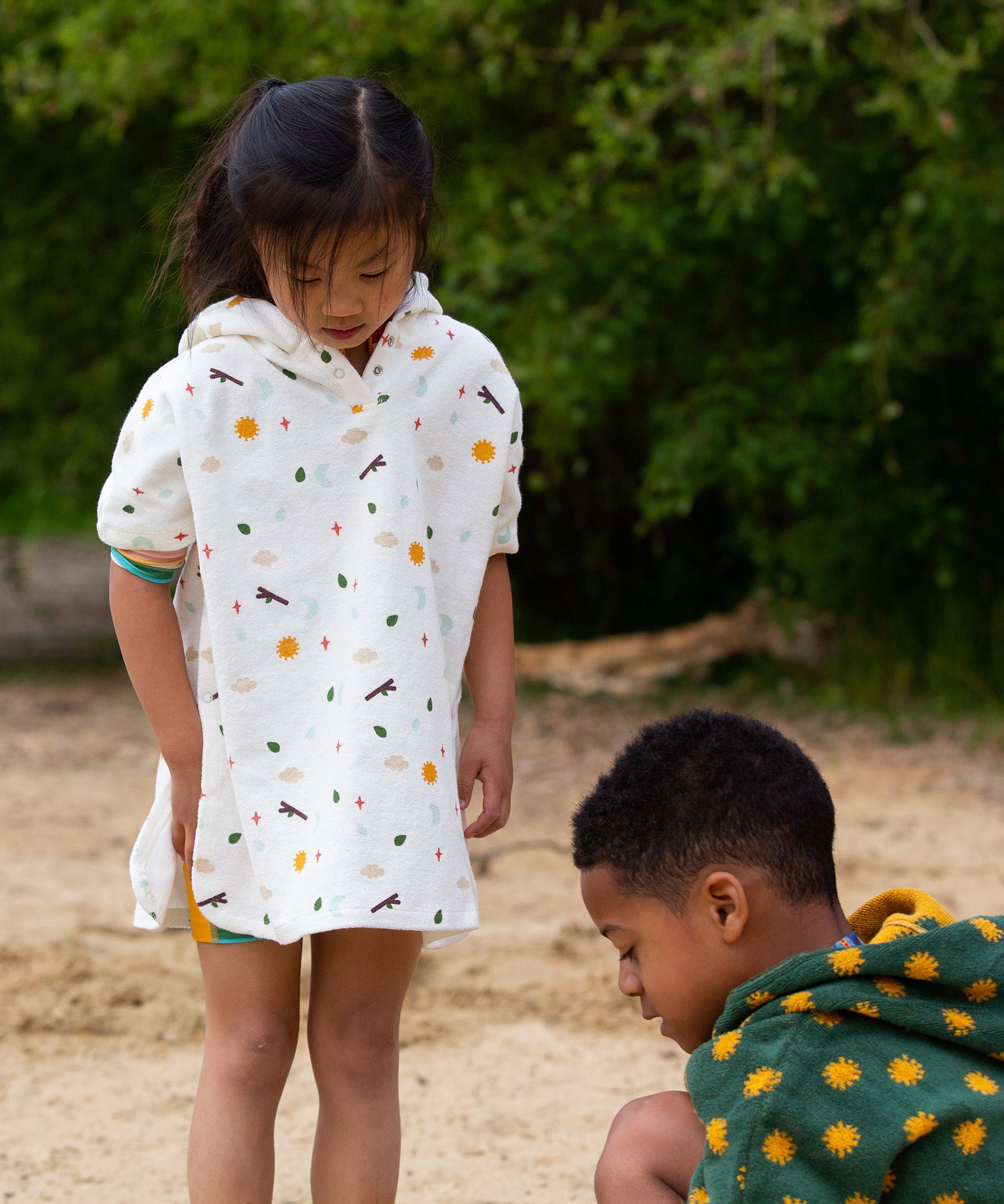 Two children playing at the beach, with the child on the left wearing the LGR Adventure Hooded Beach Towel Poncho