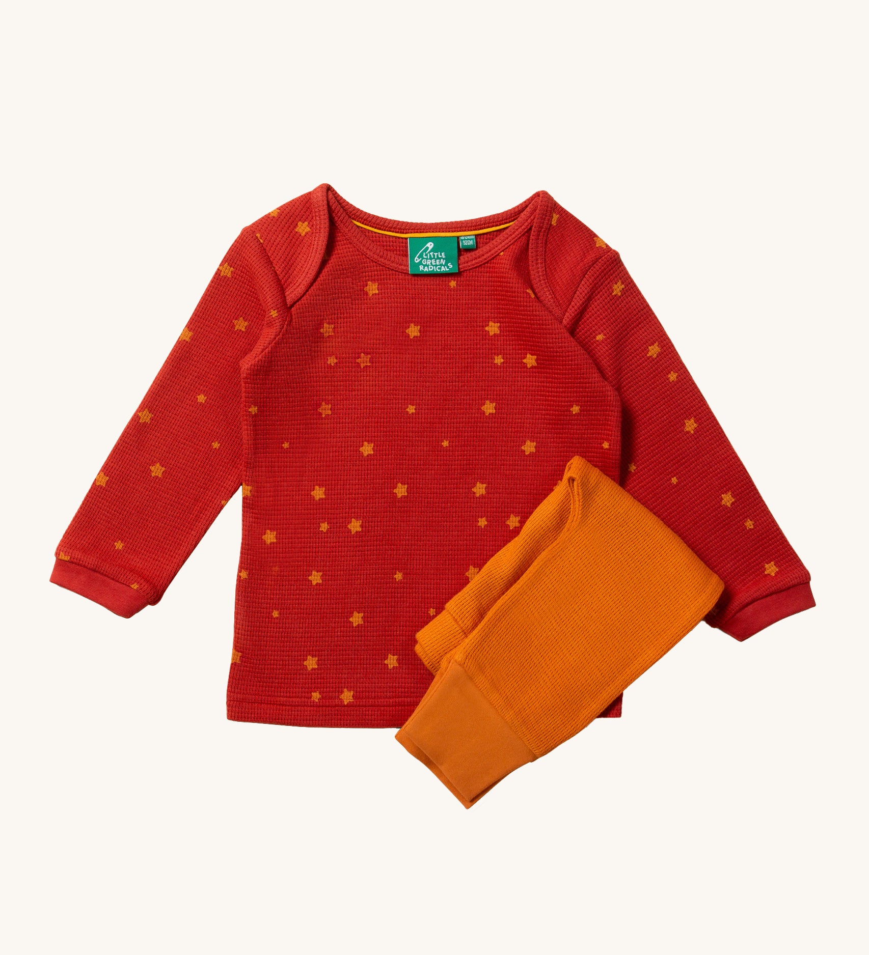 Little Green Radicals Waffle T-Shirt & Jogger Playset - Hazelnut Stars. A red long-sleeved top with little stars printed all over, and a pair of coordinating golden yellow joggers